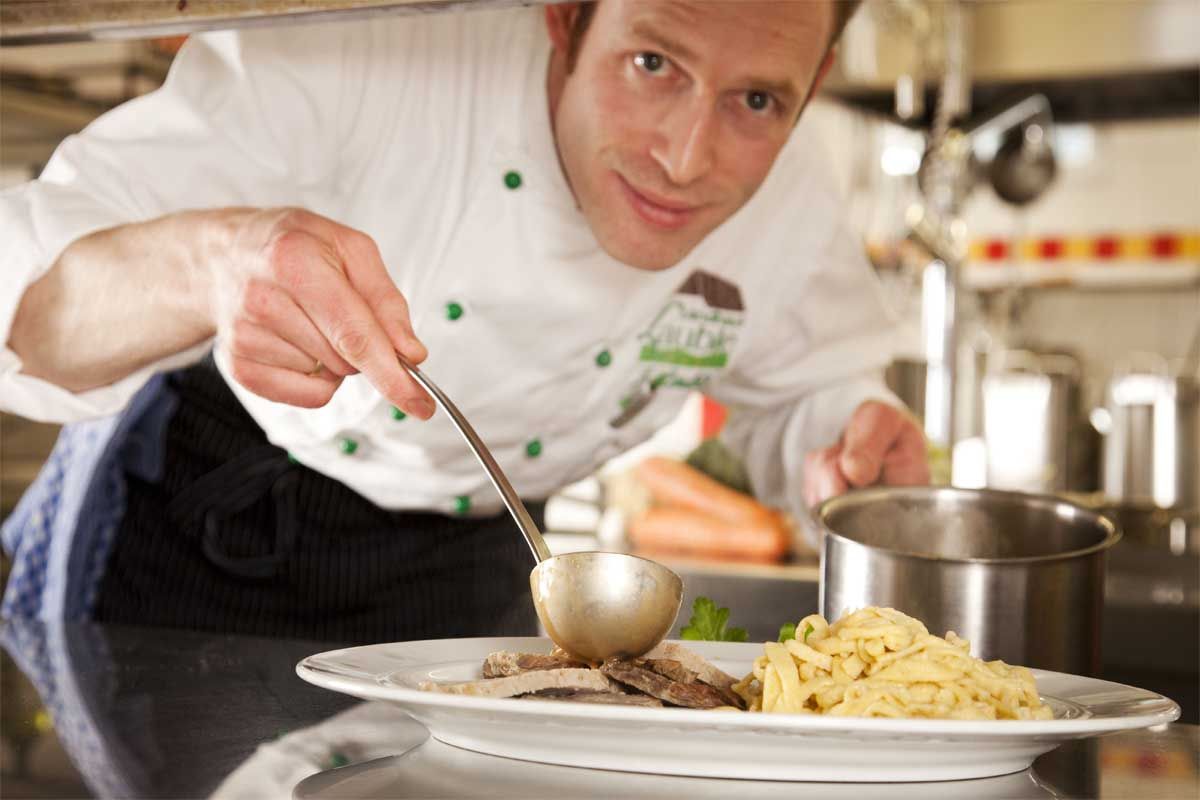 Naturpark Wirt in seiner Küche beim Zubereiten einer Hauptspeise